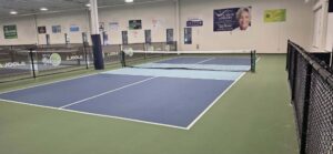 Indoor pickleball courts with Rt. 12 Pickle and JOOLA branding on the fence dividers in West Boylston, Massachusetts