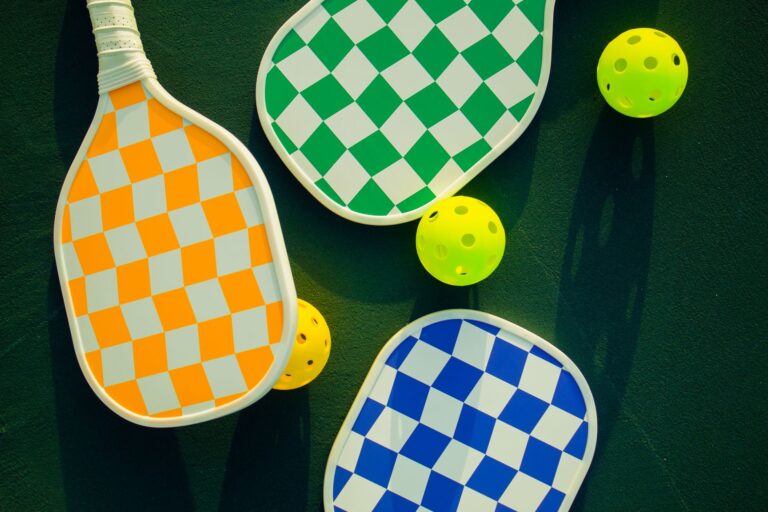 Pickleball paddles and balls laid out on a sunny court - the best pickleball paddles for beginners in 2026