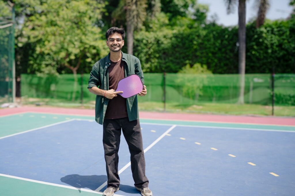 A player holding a paddle on an outdoor pickleball court, like the lighted courts in Milford CT