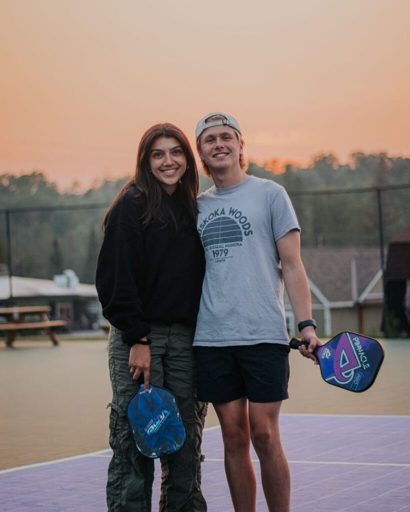 Two players holding paddles on an outdoor court at sunset, the kind of evening session that defines pickleball in Essex Junction