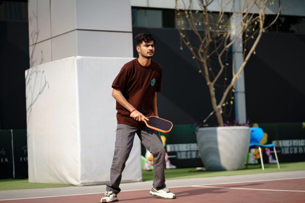A pickleball player concentrating during a solo practice session on an outdoor court
