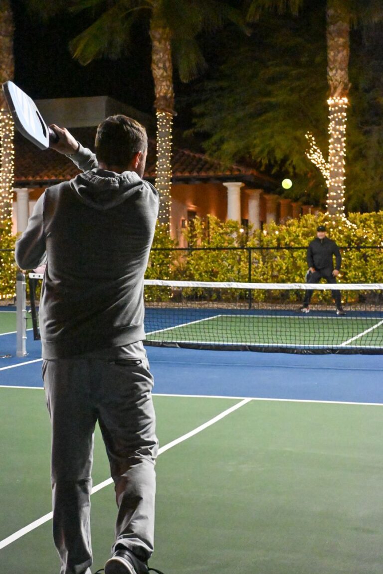 14mm vs 16mm pickleball paddle choice: a player winding up a groundstroke on an outdoor court at night