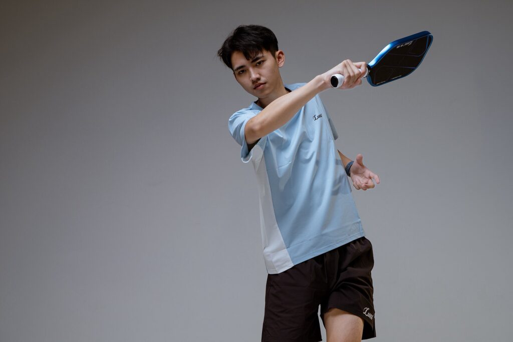 A young player hitting a forehand, the age group competing in college pickleball in New England