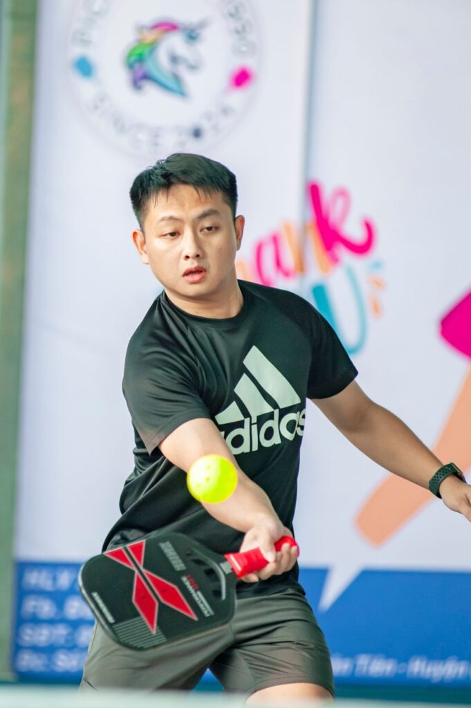Defend against stacking in pickleball: a player tracking the ball at contact while the opposing team switches sides