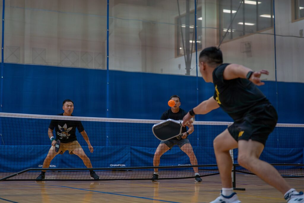 Fastest growing pickleball states: an indoor doubles pickleball rally at the net