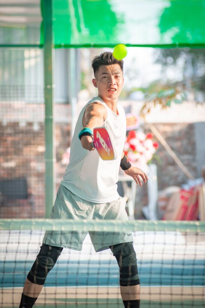 Fourth shot in pickleball: a player at the net volleying a ball out of the air