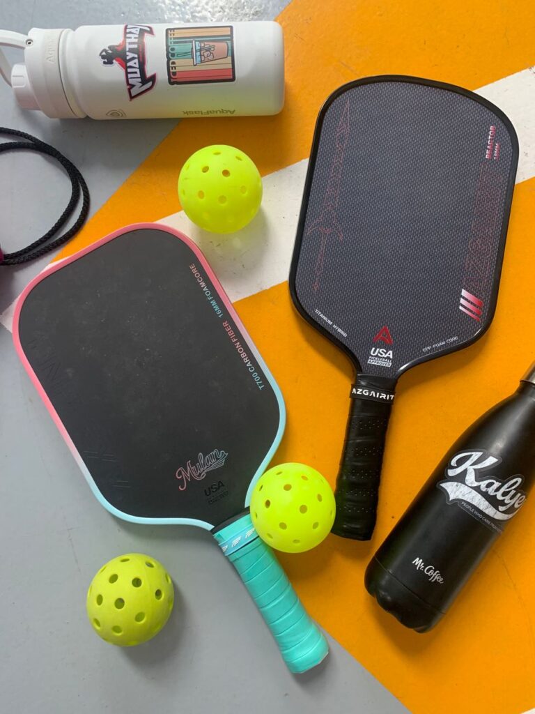 Paddles, balls and water bottles courtside before a game of pickleball in Biddeford Maine