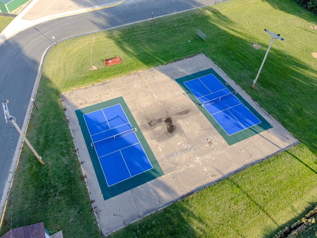 Aerial view of two dedicated outdoor pickleball courts with nets in a town park, similar to the six courts for pickleball in Brattleboro VT