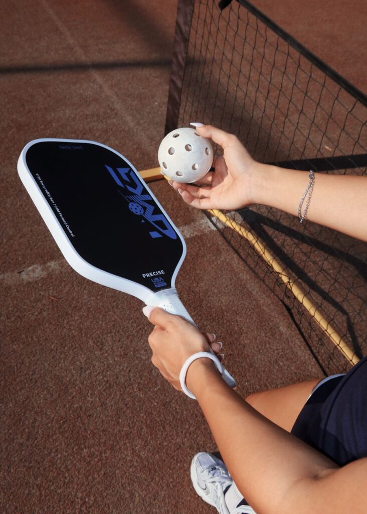 Paddle and ball courtside, illustrating a guide to pickleball in Lewiston, Maine