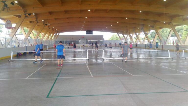 Players on portable nets over shared court lines, the kind of setup for pickleball in Montpelier VT