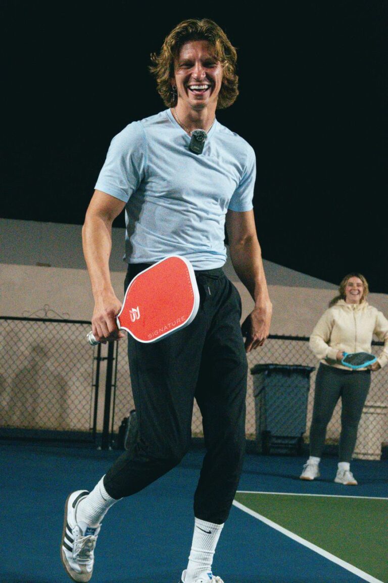 Pickleball paddle length compared: two paddles of visibly different shape and length on an outdoor court