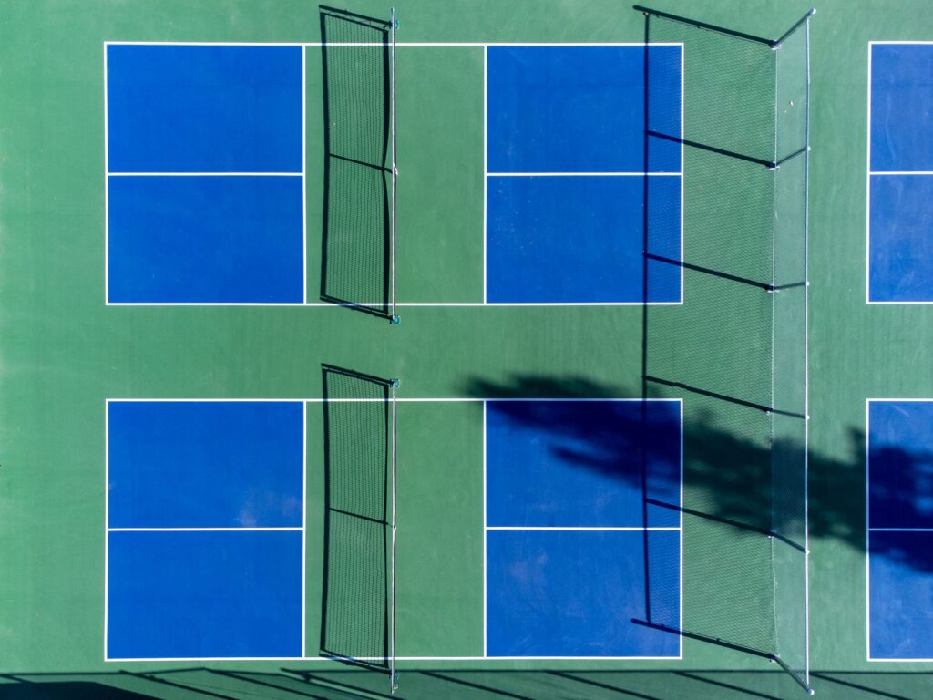 Overhead view of blue and green pickleball courts with nets