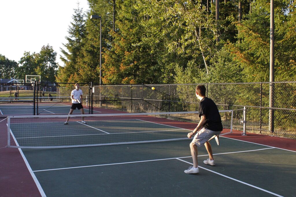 Two pickleball players in a baseline rally on an outdoor court, illustrating a pro spotlight on Anna Leigh Waters
