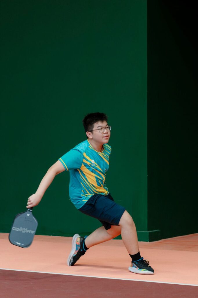 T700 pickleball paddles explained: a player lunging with a paddle on an indoor court