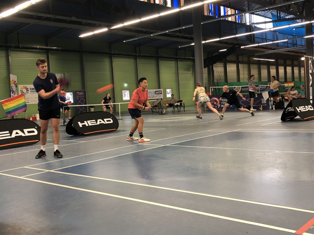 Doubles players in a tournament match on an indoor pickleball court, the kind of event that APP Tour Golden Ticket qualifiers run