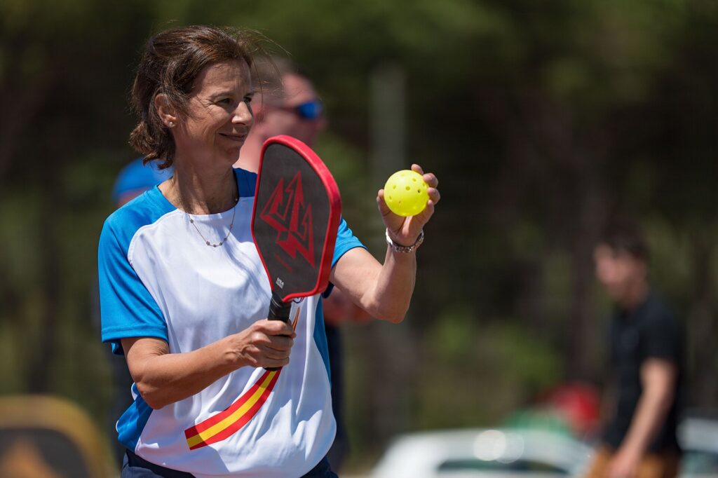 Pickleball player holding a paddle and ball before a rated match, for a guide to DUPR Plus