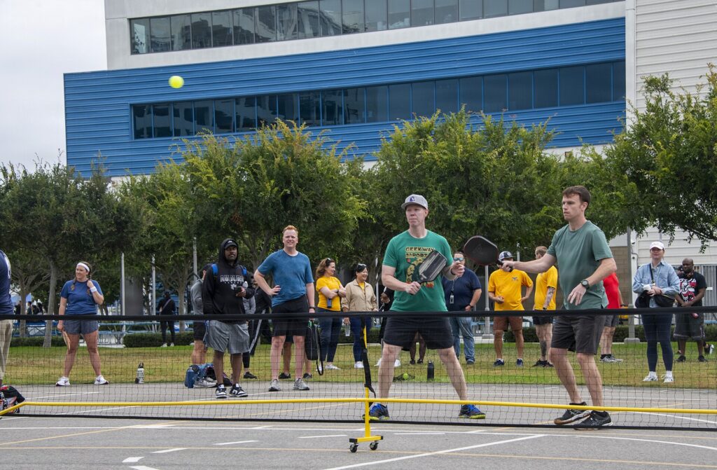 Outdoor doubles point with a crowd watching, illustrating our guide to MLP scores and standings