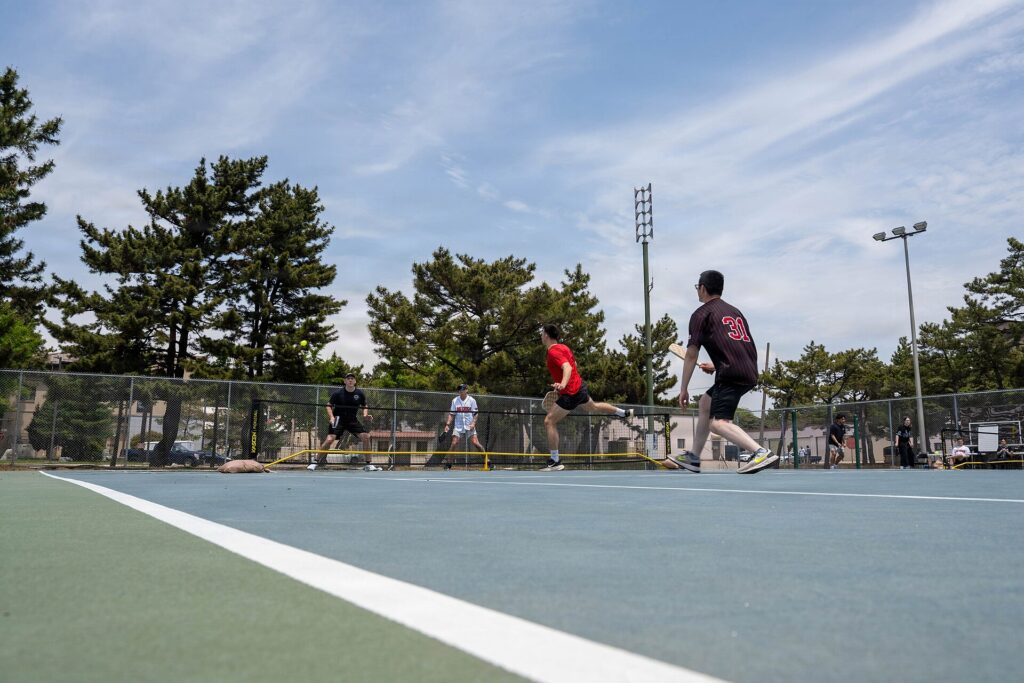 Doubles game on an outdoor court with a portable net, illustrating new pickleball courts in Rhode Island
