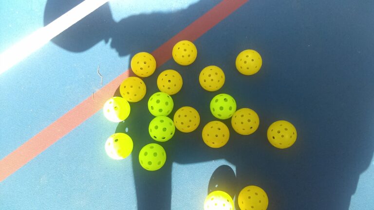 Yellow and green pickleballs on an outdoor court, ready for open play pickleball in Exeter
