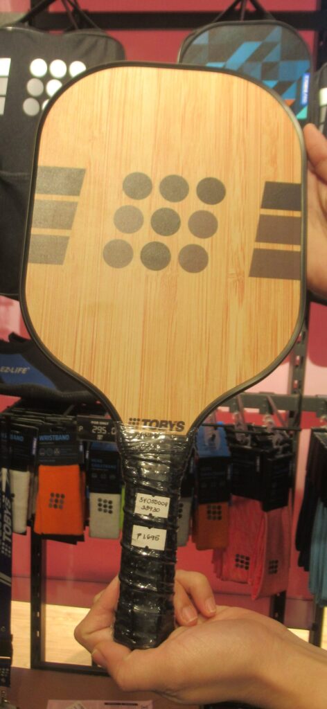 A full pickleball paddle face held up by its handle, for a guide to pickleball paddle twist weight