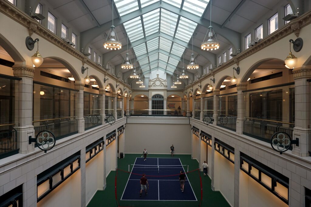 Doubles game on an indoor pickleball court, illustrating a report on the Picklr bankruptcy filing and New England clubs